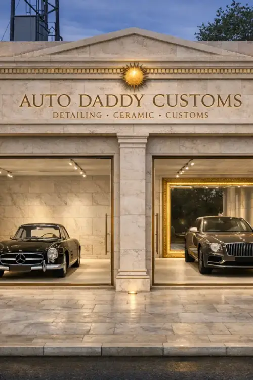 Auto Daddy Custom Stone storefront titled 'AUTO DADDY CUSTOMS' with two luxury cars visible in glass bays inside.